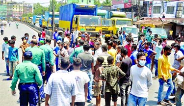 Transport workers stage a demonstration blocking roads at AK Khan intersection in Chattogram on Saturday demanding food and financial assistance during the government announced public holiday.