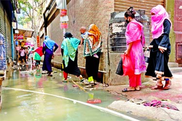 Women crossing through a by-lane with huge inconvenience as wastewater overflowed from a nearby drain amid poor drainage system in the capital. This snap was taken from Mouchack area on Saturday