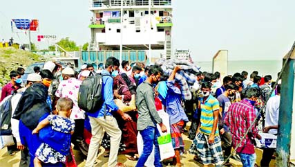 Hundreds of Dhaka-bound passengers crowd to get in a ferry at Douladia ferry terminal in Rajbari on Friday ignoring social distancing guidelines. Photo: Collected