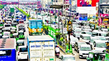 A long queue of vehicles hangs around on the airport road at Banani on Sunday, as traffic picks up with people retuning to work amid a relaxed nationwide shutdown to prevent spread of coronavirus.