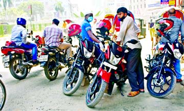 Pathao bikers wait for riders in the capital's Motijheel area on Tuesday ignoring social distancing protocol.