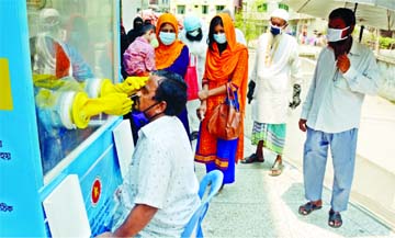 A health worker collects swab from a man to test for Covid-19 at a booth in the city's Jatrabari Community Center on Thursday amid spike in coronavirus cases in the country.