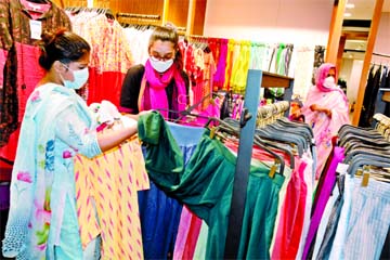 A customer browses through dresses at an outlet of local brand Aarong at Wari in Dhaka on Friday.