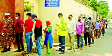 Anxious people, mostly members of Police and Fire Service, stand in a long queue at the Bangabandhu Sheikh Mujib Medical University's fever clinic in Dhaka on Sunday for coronavirus screening.