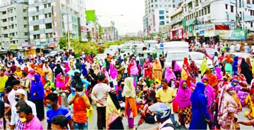 Garment workers block road at Shyamoli in Dhaka on Tuesday, demanding payment of arrear salaries and Eid bonus.