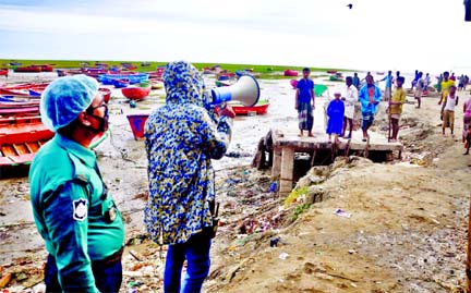 Volunteers urge people to evacuate to shelters at Pahartali coastal area in Chattogram on Tuesday ahead of the expected landfall of Cyclone Amphan.