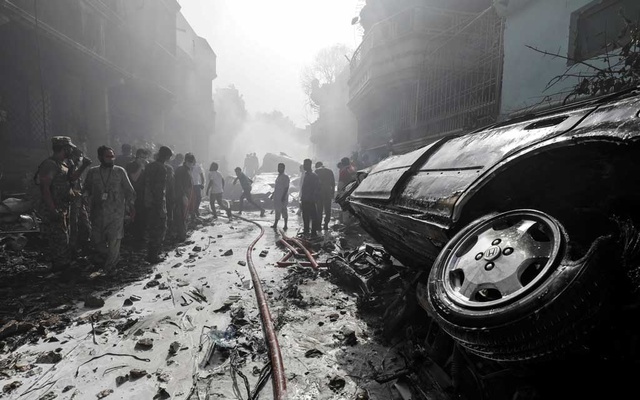 Rescue workers gather at the site of a passenger plane crash in a residential area near an airport in Karachi, Pakistan May 22, 2020. REUTERS