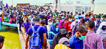 Thousands of holidaymakers throng at Shimuliya Ferry Terminal in Munshiganj to return to the capital on Thursday ignoring the risk of coronavirus infection during nationwide lockdown.