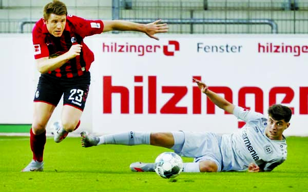 Freiburg's Dominique Heintz and Leverkusen's Kai Havertz (right) challenge for the ball during Friday's match the Bundesliga.