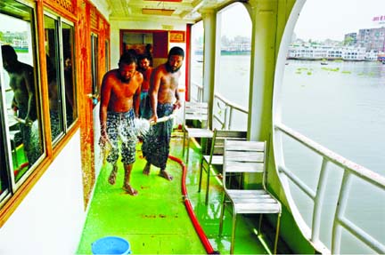 Labourers cleaning a launch at the capital's Sadarghat Terminal on Saturday as Water Transport services on 34 river routes across the country resumes today (Sunday) after about two months.