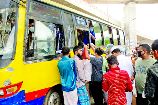 Passengers try to get in a bus at the capital's Jatrabari area on Sunday as some public buses return to the city roads a day before reopening of public transport after the nationwide shutdown.