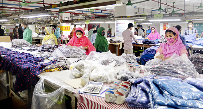 Workers of Urmi Garment work at the production floor on Monday maintaining health guidelines.