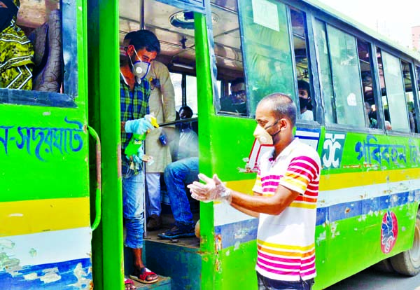 Bus passengers getting into the bus after using germ-free medicine on hands. The snap was taken from the city's Shahbag on Tuesday.