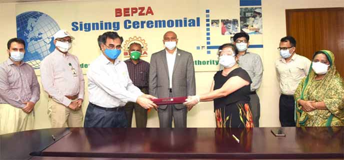 Mohammad Faruque Alam, Member (Engineering) of BEPZA and Kang Yanhong, Managing Director of Ms Unicorn Leather Goods Factory Ltd, exchanging documents after signing an agreement at BEPZA Complex in the capital on Wednesday.