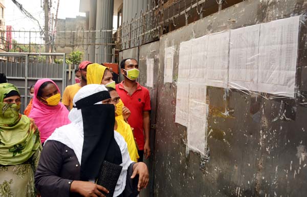 Employees of Knit Wear Limited in the city's Kamalapur area watching the retrenchment list of names of the employees hung in the notice board of the factory on Saturday.