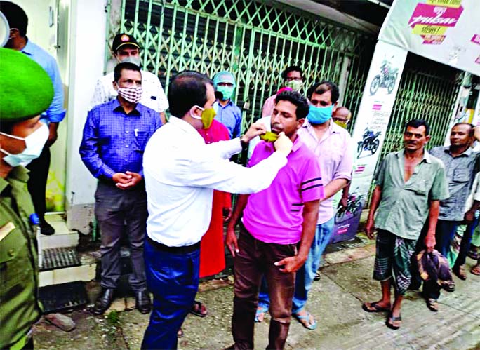 Deputy Commissioner of Kurigram Rezaul Karim distributing masks among the bus drivers and others during his visit to different bus counters of the district on Saturday.