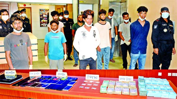 RAB personnel produce the members of an alleged credit card fraud gang, who were arrested from the capital and Bhanga upazila of Faridpur district before the media on Sunday.