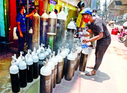 Oxygen cylinders pile up on a footpath in the city's Moghbazar area for sale on Sunday as people who are required to use oxygen rush to buy those after they find it hard to get the facility at hospitals.