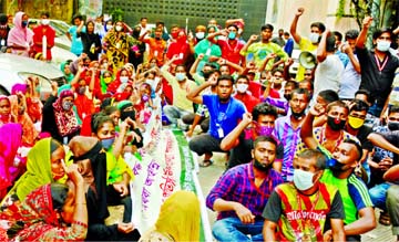 Workers chant sloganus in front of Sromo Bhabon in Dhaka on Sunday protesting their retrenchment.