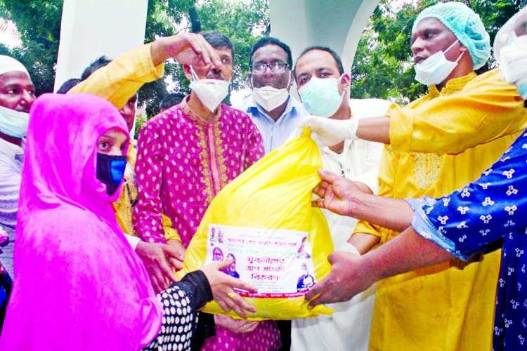 Councillor of 38 number Ward of DSCC Ahmed Imtiaz Mannafi distributing relief materials among the destitute on behalf of Bangladesh Juba League Chairman Sheikh Fazle Shams Parosh at Bahadur Shah Park in the city on Friday.