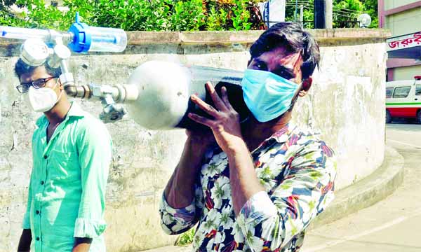 Attendants shouldering oxyzen cylinder to the hospital for their patient is in view of oxyzen crisis in Chattogram Medical College Hospital. The photo was taken on Sunday.