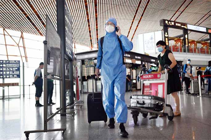 A man in a protective suit walks through Beijing's international airport on Wednesday.