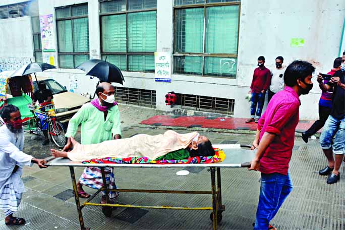 Relatives carrying a sick woman on a trolley to the Dhaka Medical College Hospital on Wednesday after running from one hospital to another for having access to medical service as both the public and private healthcare facilities in the capital continue to