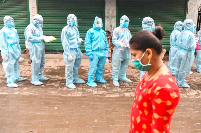 Medical staff and Rashtriya Swayamsevak Sangh (RSS) volunteers wearing Personal Protective Equipment wait to start a door-to-door medical screening inside a slum to fight against the spread of the COVID-19 in Mumbai on Wednesday.