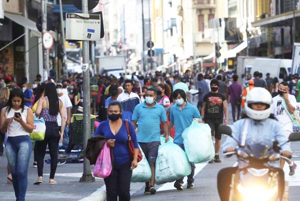 People walking with bags by a popular shopping street amid the coronavirus outbreak, in Sao Paulo on Friday.