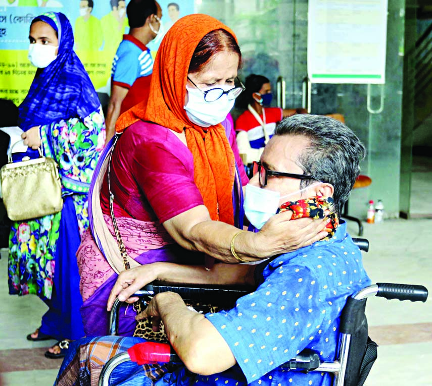 A woman consoles her corona affected husband as he was taken to DMCH for admission on Saturday.