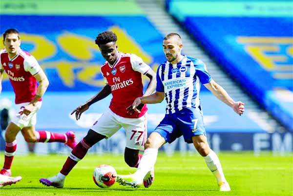 Arsenal's Bukayo Saka (front left) challenges Brighton and Hove Albion's Neal Maupay during the Premier League match between Brighton and Hove Albion and Arsenal FC at American Express Community Stadium in Brighton, Britain on Saturday.