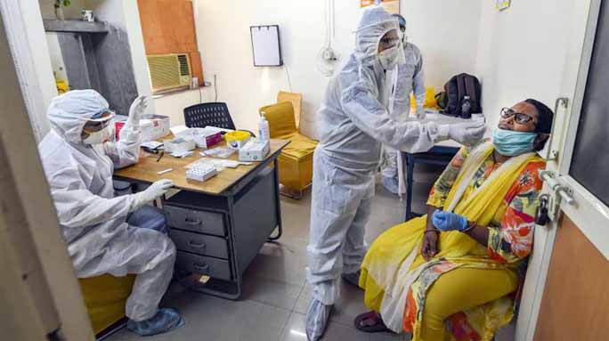 Health workers conduct Covid-19 testing at CGHS in New Delhi on Sunday.