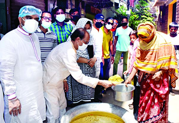 Councillor of DSCC Ward No, 46, Shahidullah Minu distributing food aid among the distressed people on Tuesday marking the 71st founding anniversary of Awami League. 1 No. Joint General Secretary of the Ward Mohammad Jashim was present, among others, on