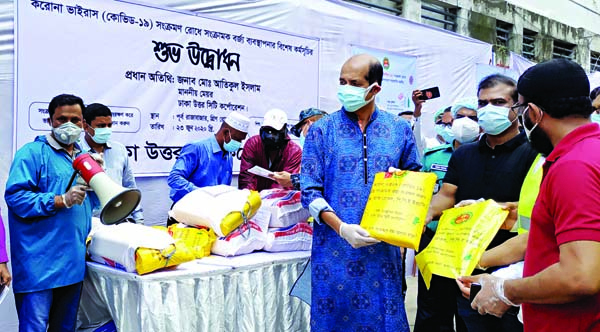 DNCC Mayor Atiqul Islam distributing Personal Protective Equipment among the commoners at the inaugural ceremony of waste management programme at East Rajabazar area in the city on Tuesday with a view to tackling coronavirus.