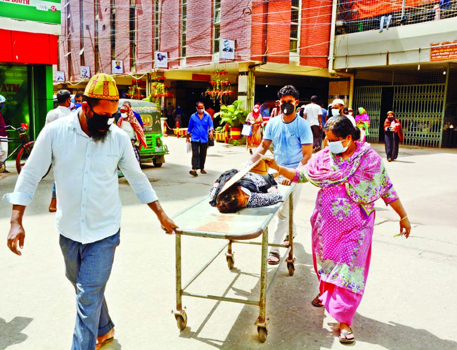 A patient is carried on a stretcher to Sir Salimullah Medical College (SSMC) in Dhaka for admission after several city hospitals turn away him amid fear of Covid-19 infection.