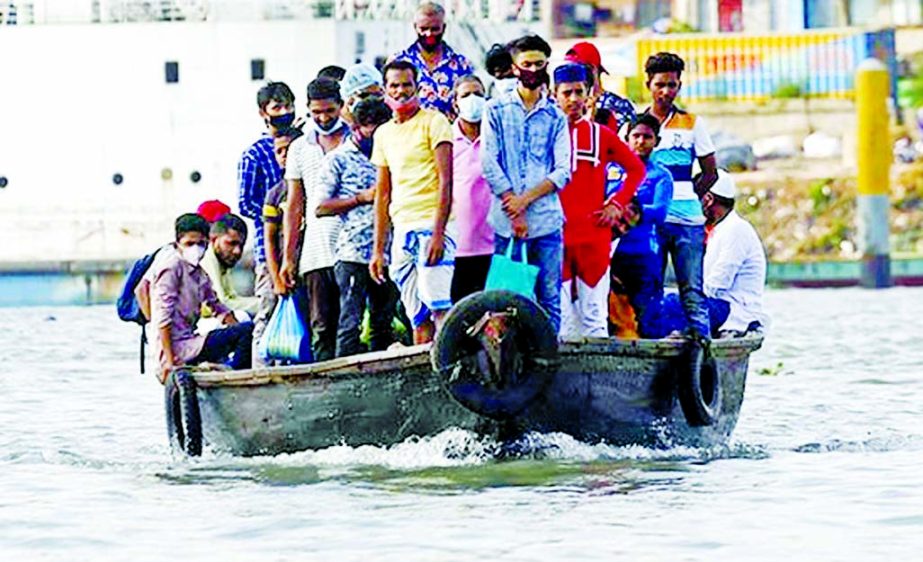 Commuters board on a small wooden boat to cross the Buriganga River on Tuesday with total disregard to physical distancing norms.
