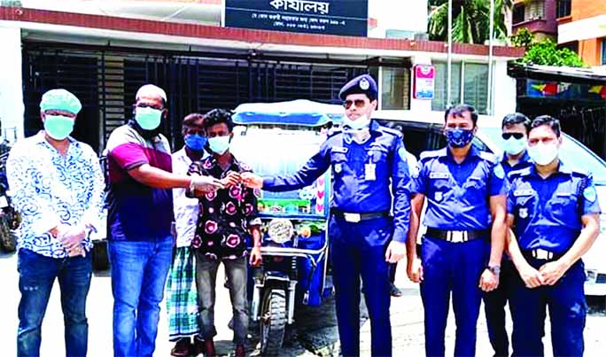 Sajib receiving the keys and papers of his new battery-run auto-rickshaw from Jahed Pervez Chowdhury, additional superintendent of Police and bKash agent, Alamgir Hossain Jewel in Chandpur on Wednesday.
