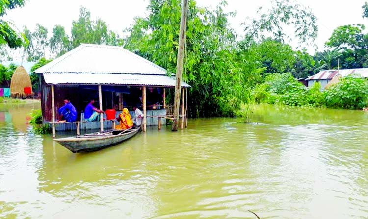 Flood water keeps a family marooned at Chilmari in Kurigram district on Sunday as water levels of all 16 rivers flowing in the district continue to swell due to heavy rainfall and onrush of water from upstream.
