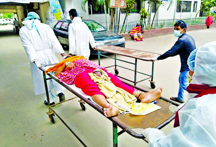 Medical staff take a mother and her new born on a stretcher for Covid-19 test as she caught in fever after giving birth of the baby at the Dhaka Medical College Hospital on Sunday.