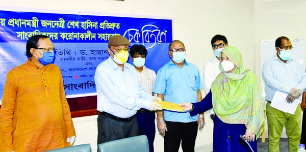 Information Minister Dr Hasan Mahmud distributes cheque of financial assistance among the corona-hit journalists at the seminar room of Bangladesh Press Institute in the city on Tuesday.