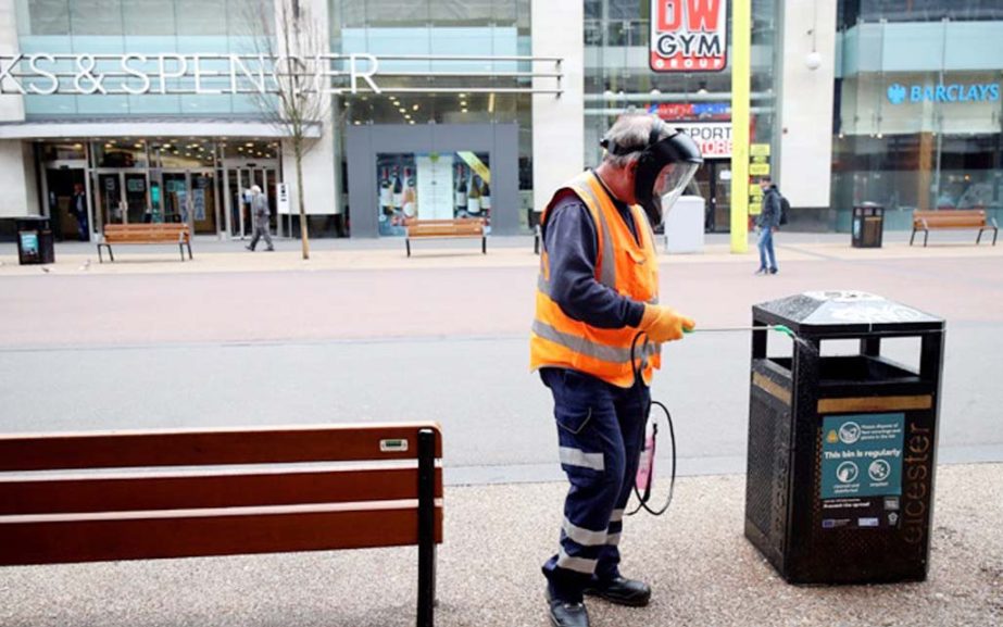 A worker disinfects a bin following the coronavirus outbreak in Leicester on Tuesday.