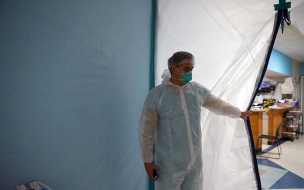 A medical worker opens a makeshift door to the United Memorial Medical Centre's coronavirus intensive care unit in Houston, Texas on Tuesday. Internet