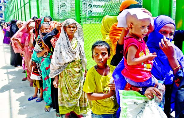 Women form a long queue to collect relief goods at Lalbagh in Dhaka with a total disregard to physical distancing norms. This photo was taken on Wednesday.