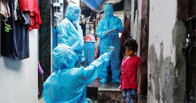 A healthcare worker checks the temperature of a resident during a medical campaign for the coronavirus disease at a slum area in Mumbai on Wednesday.