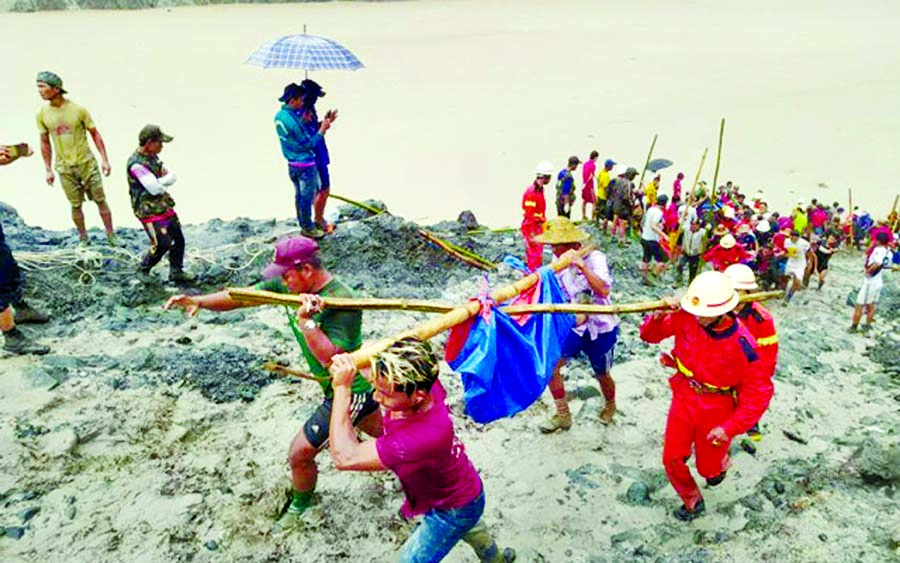 People carry a dead body following a landslide at a mining site in Phakant, Kachin State City in Myanmar on Thursday.