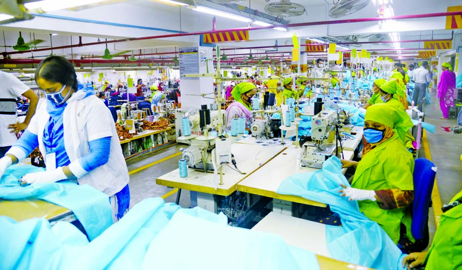 Workers are seen producing protective gowns at an apparel unit in the capital on Thursday.