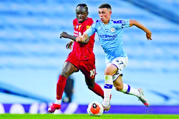 Manchester City midfielder Phil Foden (R) vies with Liverpool striker Sadio Mane during the English Premier League soccer match at the Etihad Stadium on Thursday.