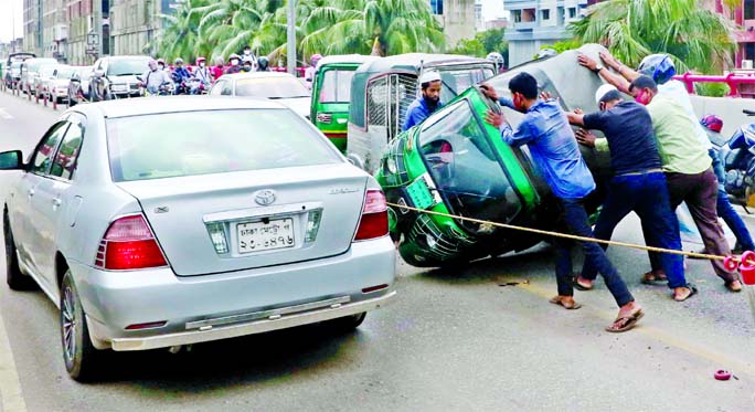 Traffic gridlock was created on Mayor Hanif Flyover after a CNG three wheeler turned turtle while crossing violating speed limit on Monday.