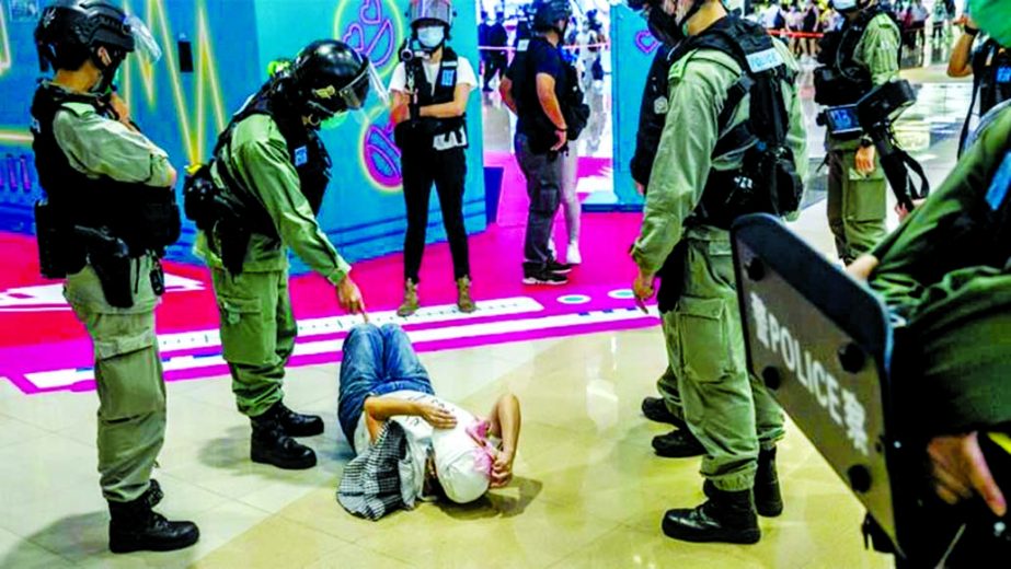 A police officer points at a woman laying down after being searched during a protest at a mall in Hong Kong on Monday.