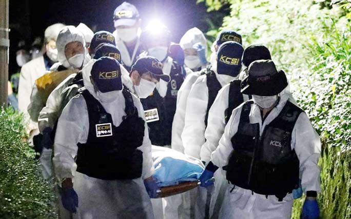 Police officers carry the body of Seoul Mayor Park Won-soon, which was found dead during a search operation in Seoul on Friday.